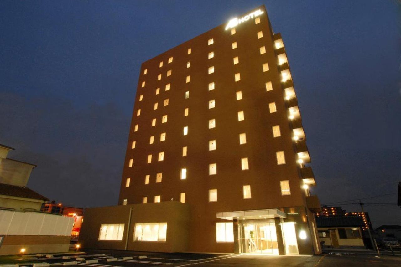Un immeuble d’hôtel à plusieurs étages, doté de fenêtres illuminées et d’une entrée imposante.