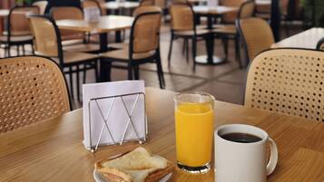 A breakfast setting with a table, chairs, and a view of the outdoors.