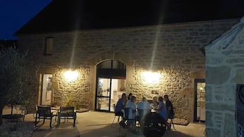 An outdoor seating area with stone walls and a building entrance.