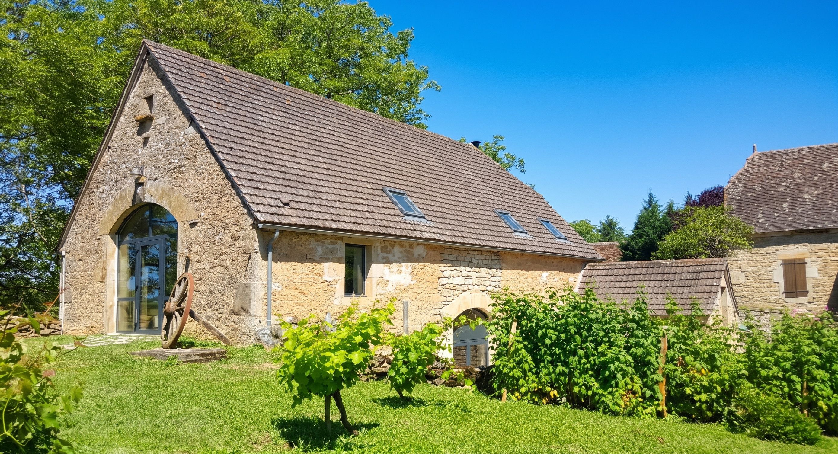 Un bâtiment en pierre doté d’un toit à deux versants et d’une petite entrée en arc de cercle.