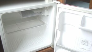 Un réfrigérateur ouvert, avec un intérieur visible, un panneau de commande sur le côté droit et une étagère en haut.