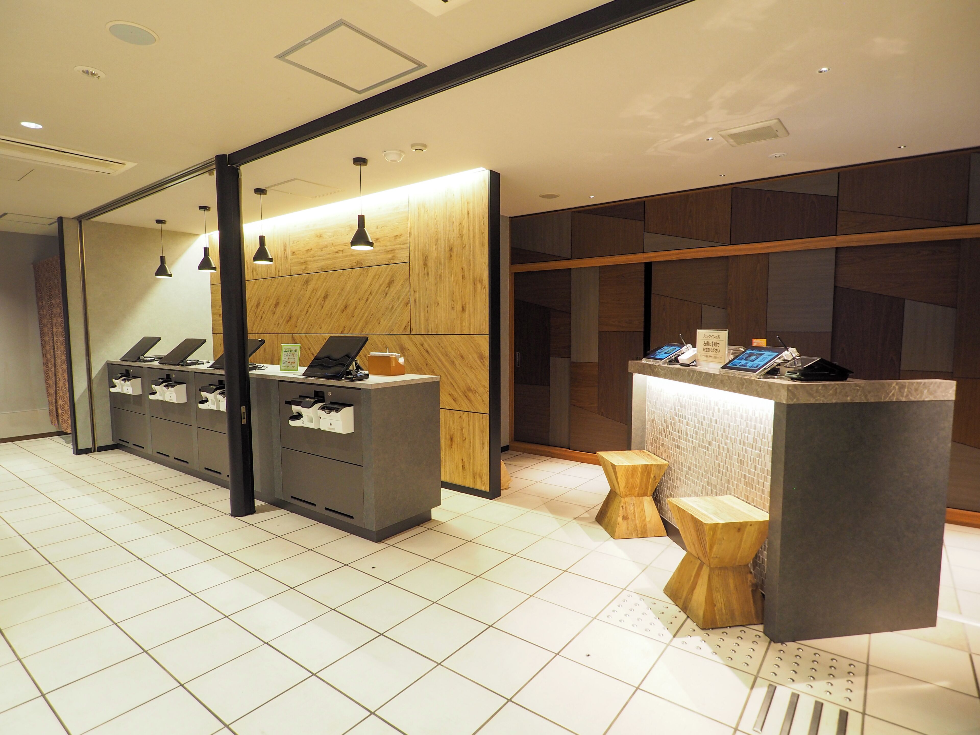 A reception area with a counter, computer stations, and a wooden wall.
