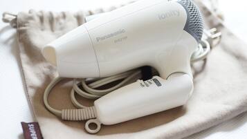Ein Panasonic Ionity Föhn mit Kabel und Netzteil auf einem beigefarbenen Tuch.