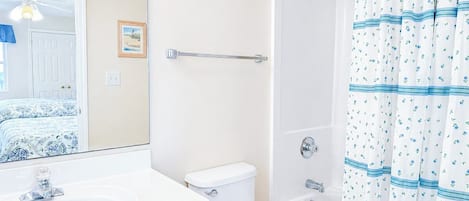 A bathroom with a white sink, toilet, and bathtub.