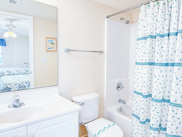 Un baño con lavamanos, inodoro y bañera blancos.