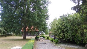 Ein Garten mit einem Kiesweg, einer Steinhlaterne und einem Steintisch.