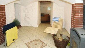 Ein gemütliches Zimmer mit Kamin, einer kleinen Sitzecke und einer Tür zu einem weiteren Raum.