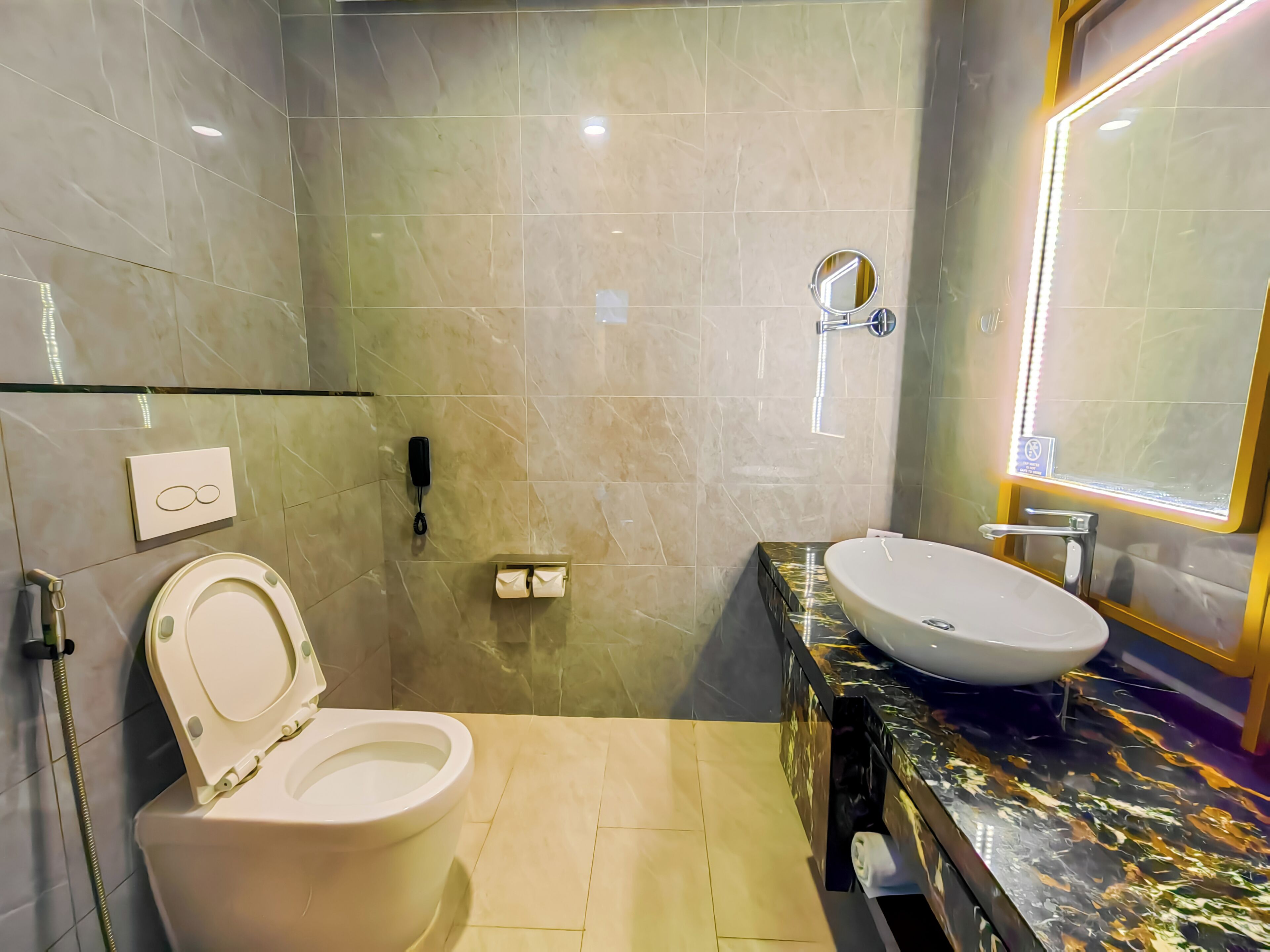 A modern bathroom with a toilet, sink, and mirror.