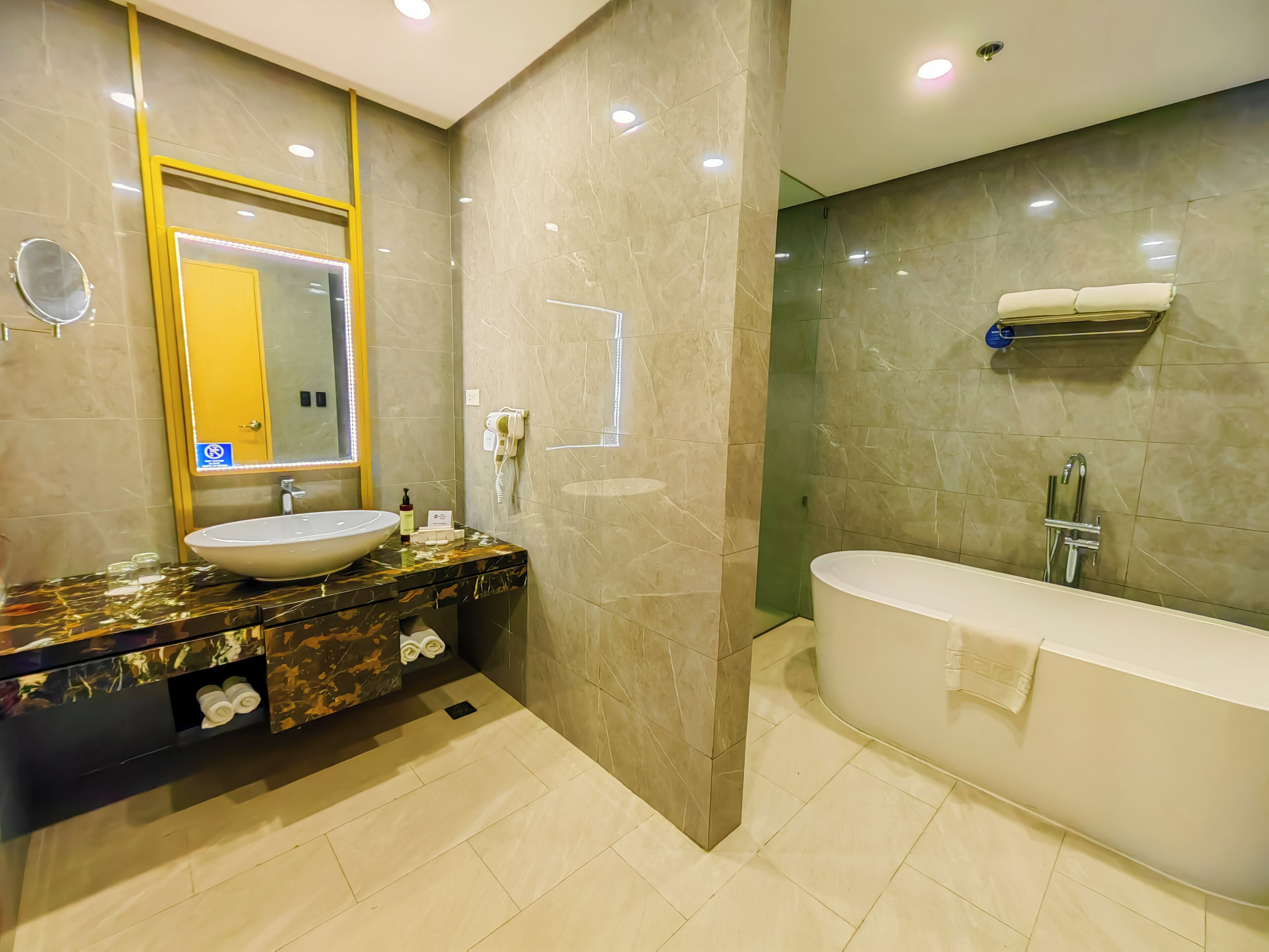 Un baño moderno con un lavamanos grande, espejo y bañera.