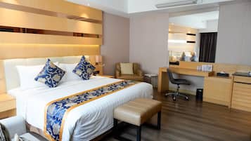 Una habitación de hotel moderna con una cama grande, un escritorio, una silla y un espejo.