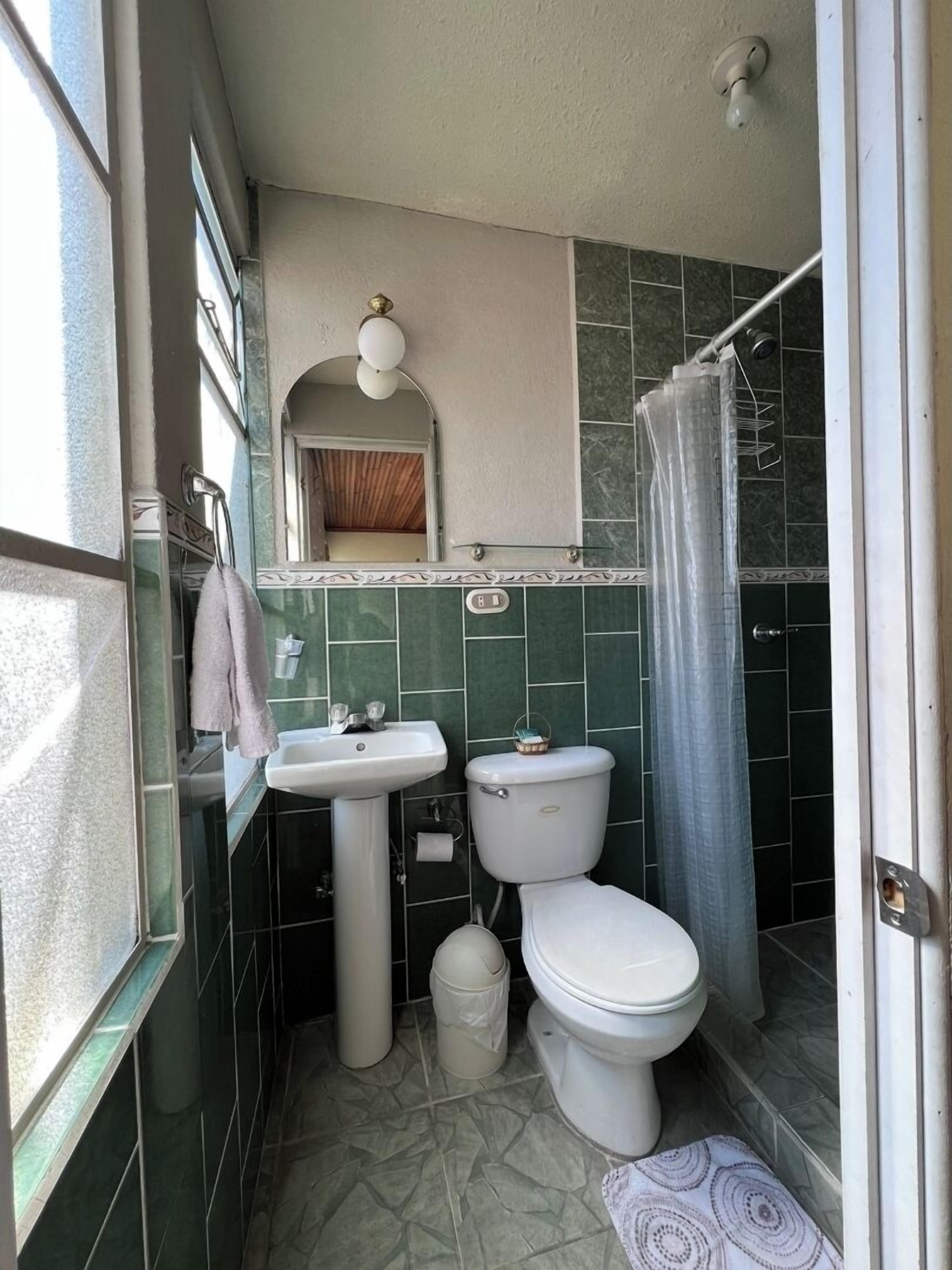 Un baño pequeño y funcional con lavamanos, inodoro y ducha.