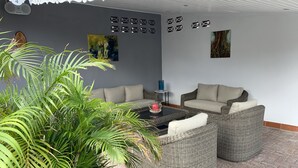 A patio area with wicker furniture, a coffee table, and a potted plant.