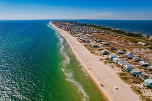Vista aérea de una zona costera con playa y varios edificios.