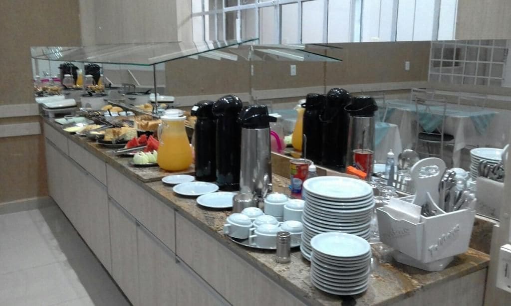 Montaje de bufé con diversas opciones de comida, salsas y utensilios para servir.