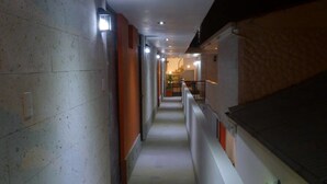 A narrow hallway with a tiled floor, a staircase on the right, and a door at the end. - Casa de Lucila (Chivay)