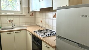 A kitchen with a gas stove, a sink, cabinets, and a refrigerator. - N107 - Numana, large three-room apartment with garden and two bathrooms (Numana)