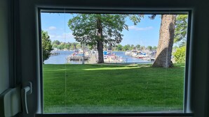 A view of a marina with boats docked, a grassy area, and trees. - bunk by the water (Bezirk Spandau)