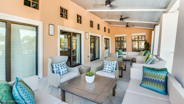 Amplia zona exterior con mobiliario diverso, incluyendo sofás y sillones, organizados alrededor de una mesa de centro.