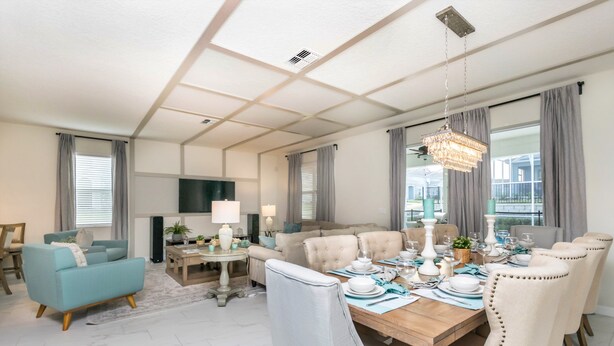 Un salón amplio con sofá, una mesa de comedor para seis personas y televisor.