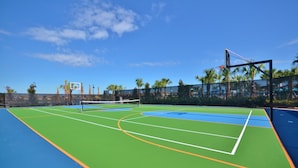 An outdoor tennis court with a net, surrounded by a fence and palm trees. - Windsor at Westside Exec Villas- 8804cordri (Kissimmee)