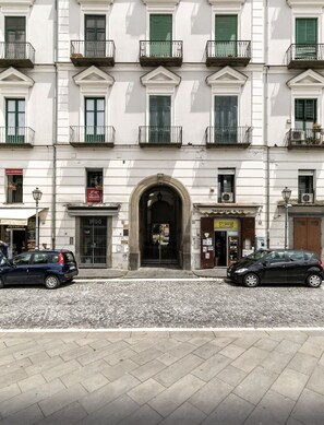 Stunning European-style building with a central entrance, green shutters, and decorative iron railings.
