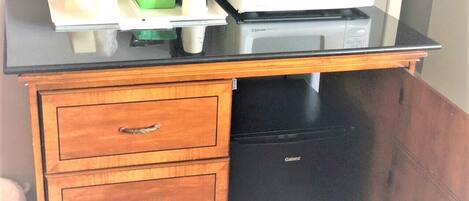 Una cocina equipada con microondas, cafetera y refrigerador pequeño.