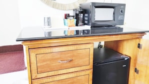 A kitchenette with a microwave, coffee maker, and a small refrigerator. - Countryside Inn (Richmondville)