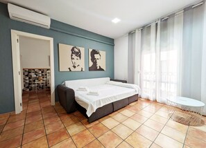 Een slaapkamer met een bed, een klein tafeltje en twee decoratieve wandpanelen.