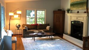 A living room with hardwood flooring, a sofa, a coffee table, a fireplace, and a globe on a side table. - A dream summer rental 30 miles from New York City in picturesque Bedford, NY! (Bedford)