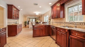 A spacious kitchen with wooden cabinets, a central island, and a large window. - A dream summer rental 30 miles from New York City in picturesque Bedford, NY! (Bedford)