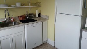 A kitchen with white cabinets, a dishwasher, a sink, and a white refrigerator. - Butte Bungalow Home, Close to uptown- 2 bdrm, 2 bath, No Cleaning fee (Butte)