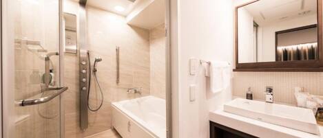 A modern bathroom with a glass shower enclosure, a walk-in bathtub, and a large mirror above the sink.