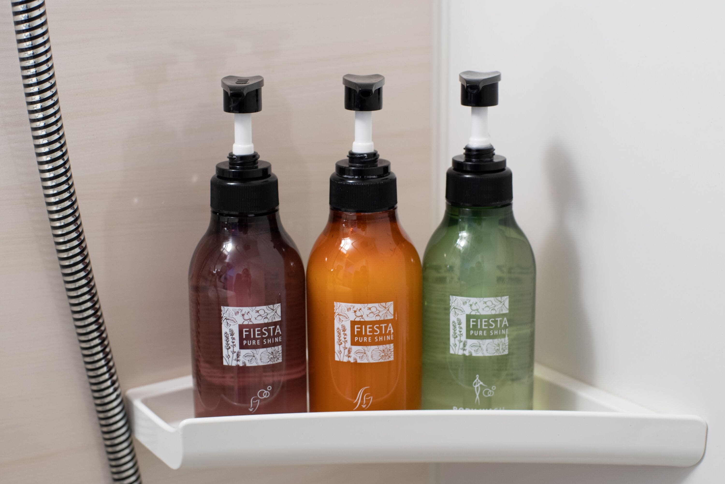 Drie flessen Fiesta Pure Shine op een witte plank.