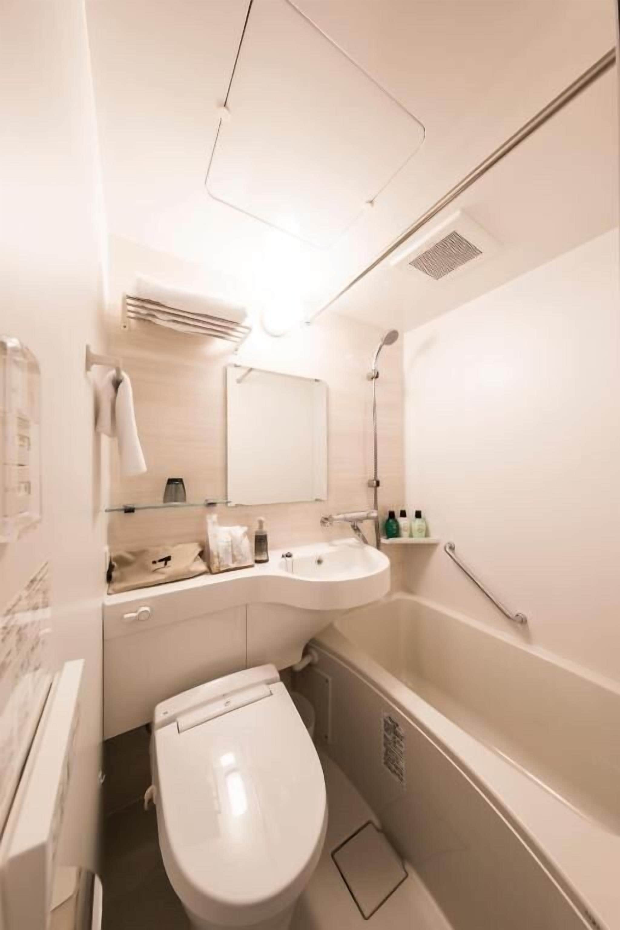 A modern bathroom with a toilet, sink, and shower.