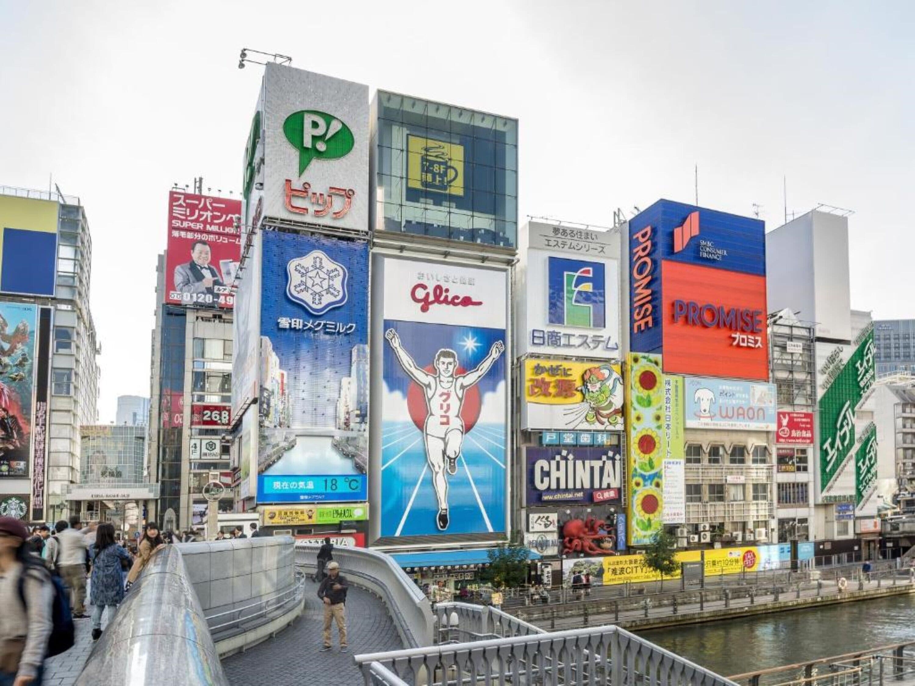 Un quartier urbain animé, avec de nombreux commerces et une grande quantité de publicités.