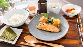 A meal with rice, fish, and vegetables on a tray.