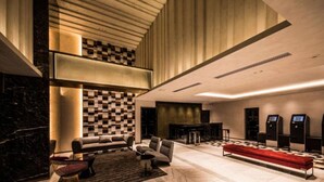 A spacious lobby with a checkered wall, a red bench, and a bar area with a counter and seating. - The Rise Osaka Kitashinchi (Osaka)