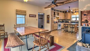 Una cocina amplia con armarios de madera, una isla grande y un comedor con mesa y sillas de madera.