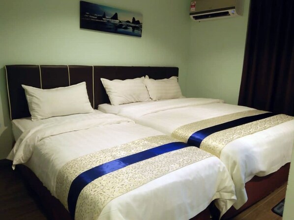 A double bed with a headboard, two pillows, and a decorative blue and gold bed runner.