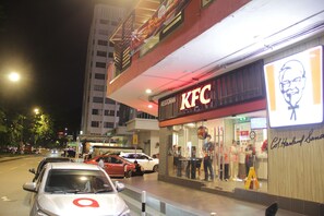 A KFC restaurant with a large illuminated sign and a visible menu board.