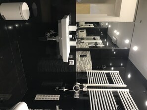 Features a sleek sink, toilet, and large mirror.