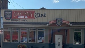 A building with a sign that reads "Conspiracy Coffee Co. Breakfast - Lunch" and "Conspiracy Coffee Co. Bakery". - Quiet Beautiful Cabin in the Woods (Fall Brook)