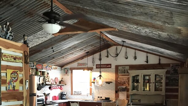 A rustic interior with a dining area, kitchen, and seating.