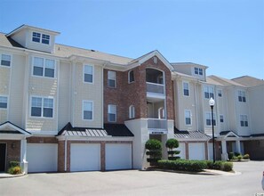 Stylish residential building with a brick and siding exterior, featuring a flat roof and central balcony.