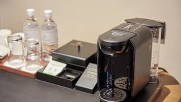 A coffee machine on a counter with a tray of water bottles and a coffee pod.