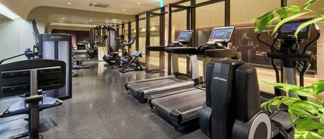 A gym with treadmills, weight machines, and exercise bikes.
