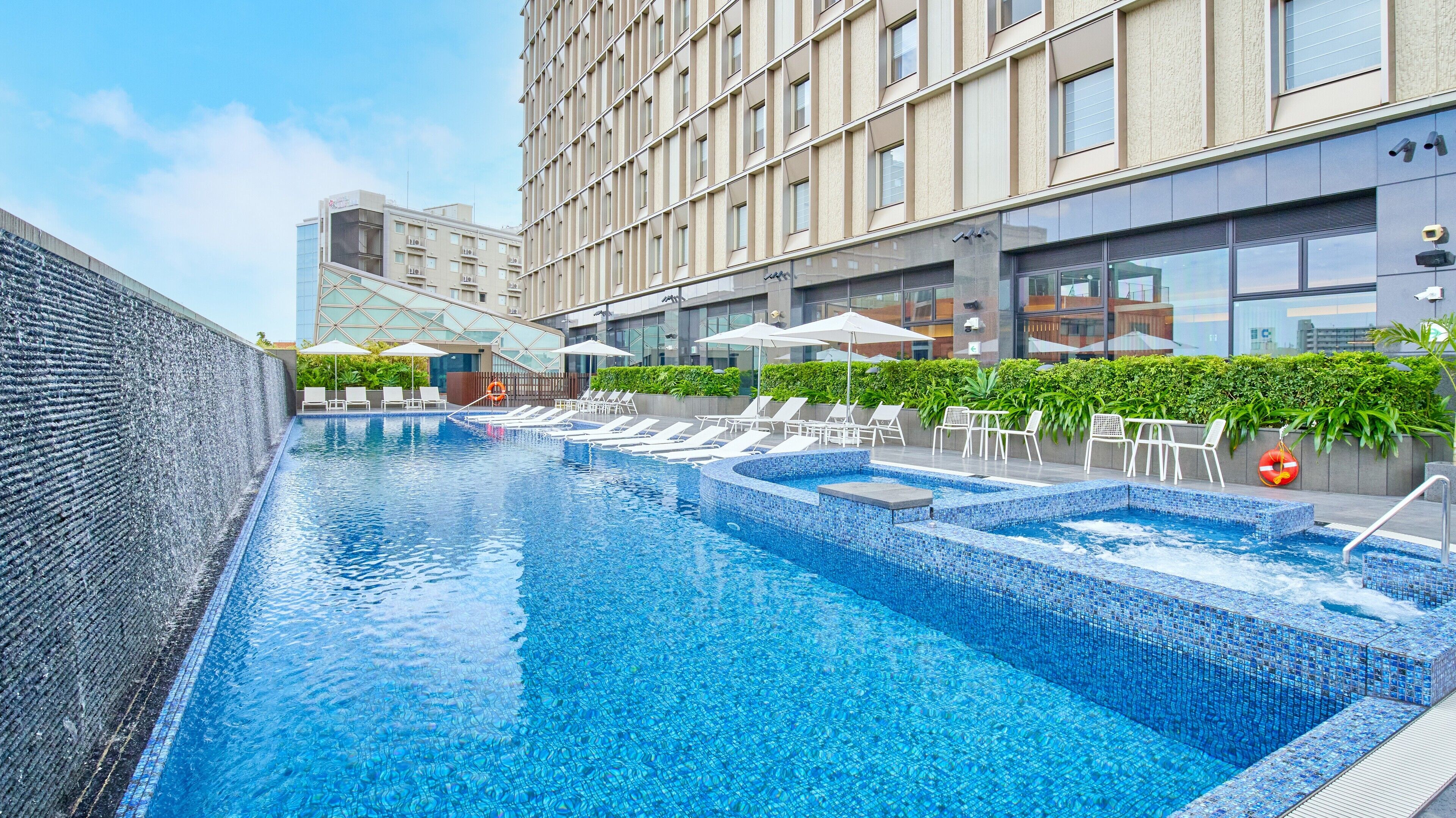 Una piscina al aire libre de temporada, sombrillas