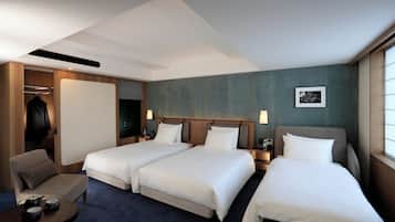 Habitación de hotel con dos camas, una zona de estar y un armario.