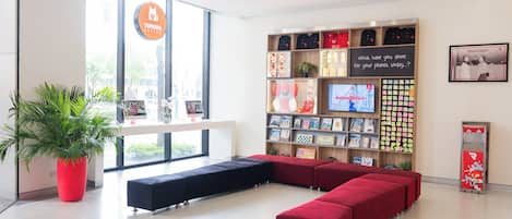 Un interior moderno con una zona de estar, un ventanal grande y una pared que exhibe varios objetos.
