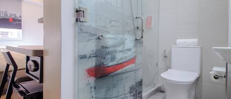 Une salle de bain moderne avec une douche à parois de verre, des toilettes blanches et un lavabo.